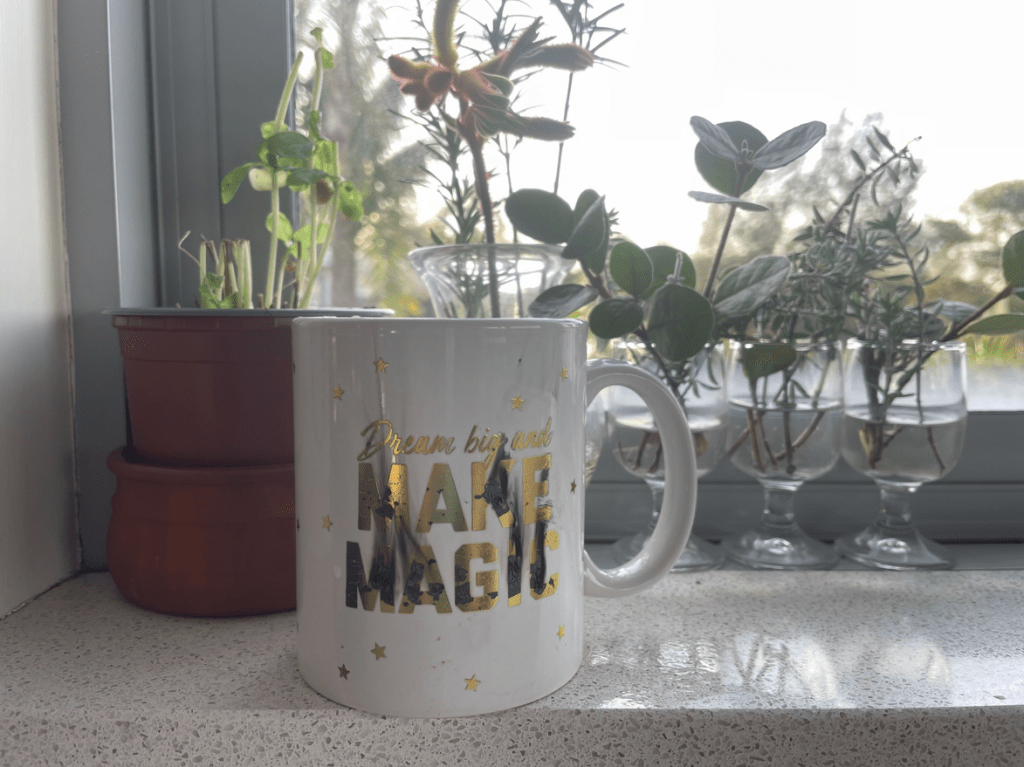 the photograph of a coffee mug with the text "dream big and make magic" with the letters all burnt