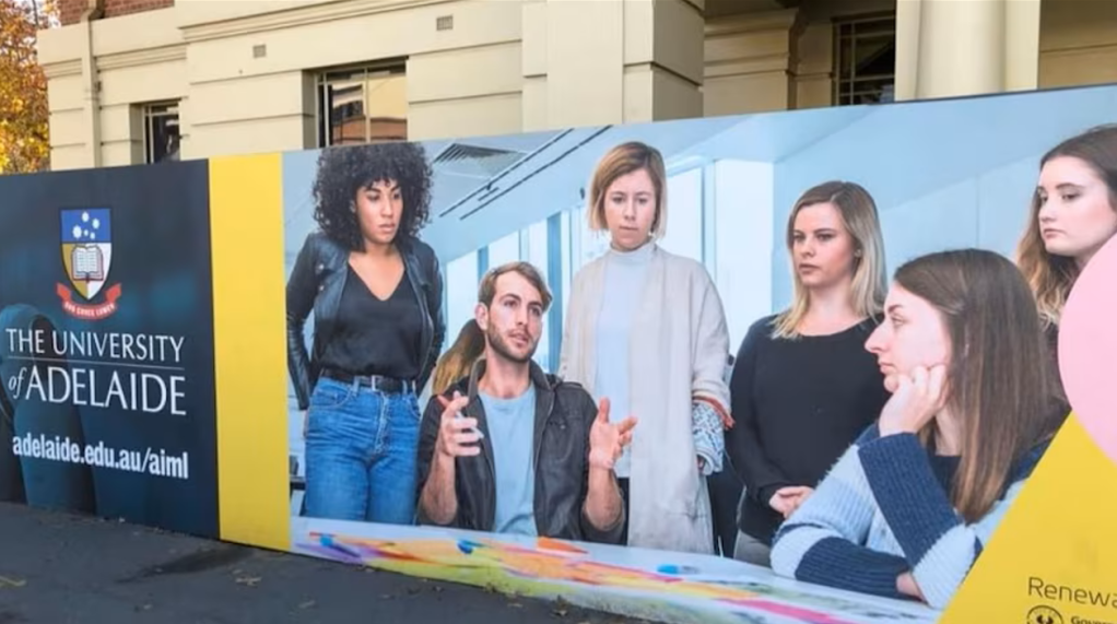 Image of a man explaining something to a group of women placed on a construction hoarding